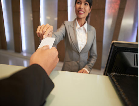 Receptionist hands IC card to visitor