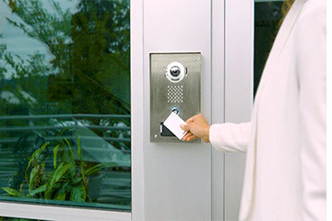 A staff member is unlocking the door by holding a card against access control built in video door station