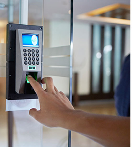 A staff member is unlocking the door using fingerprint authentication for access control
